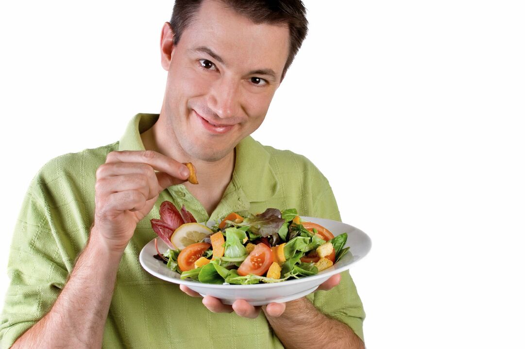 Lelaki makan salad sayur-sayuran untuk potensi